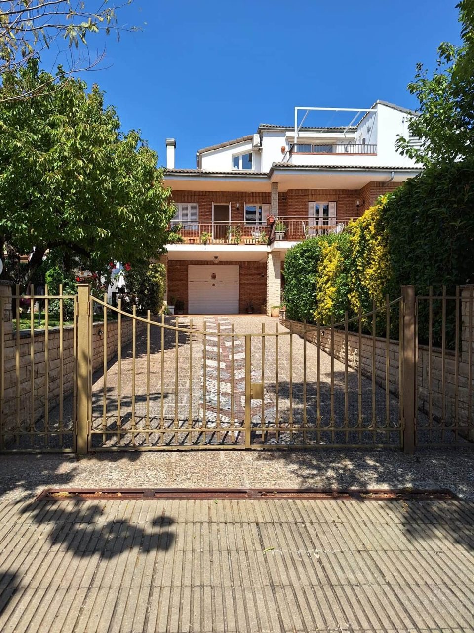 Façana de la casa envoltada de vegetació